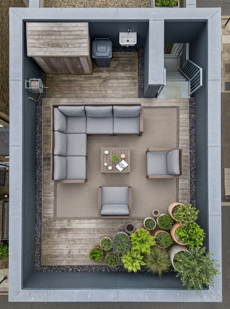 Rooftop terrace viewed from above showing furniture and rugs squared up to the building edges